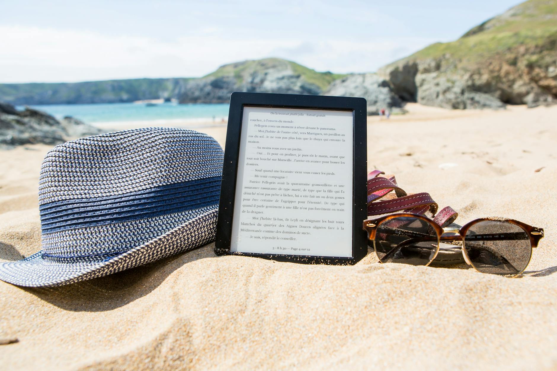 What Are The Best Travel Gadgets For Stress-Free Exploration? 5 shallowfocus photography of fedora hat photo frame and sunglasses on beach