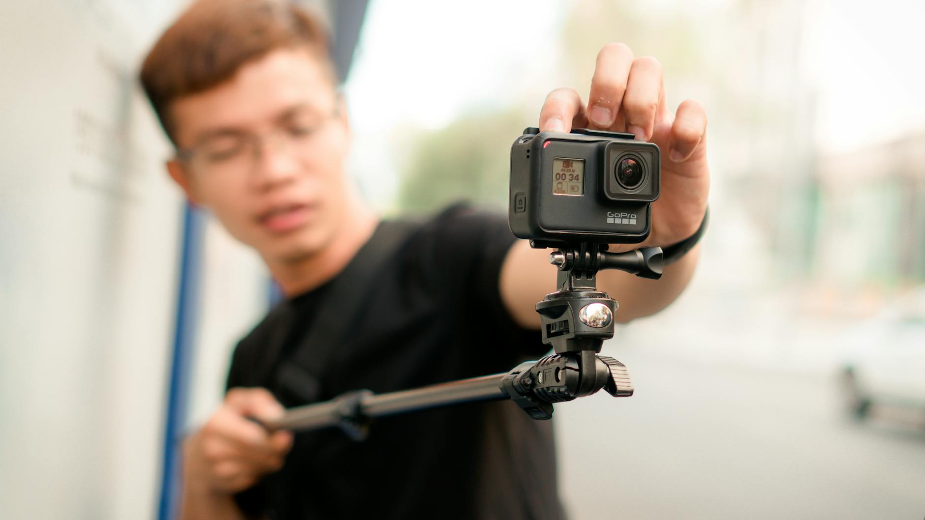 What Are The Best Travel Gadgets For Stress-Free Exploration? 3 man holding monopod with action camera